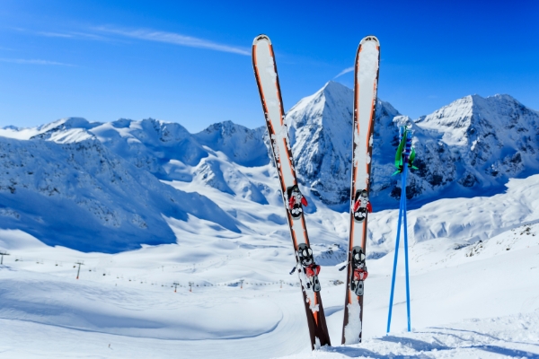 A pair of skis and poles placed upright and sticking out of deep snow.