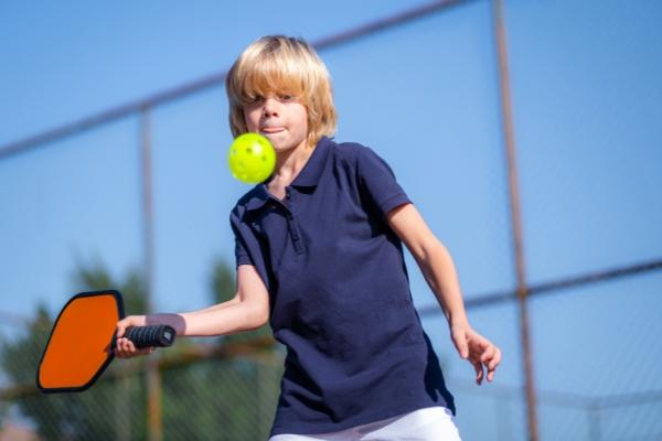 A boy trying out a pickleball paddle. Pickleball paddle demos Boston