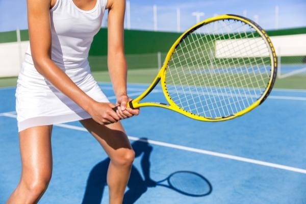 A female tennis player holding a tennis racquet during a game. Tennis racquet technologies 2024