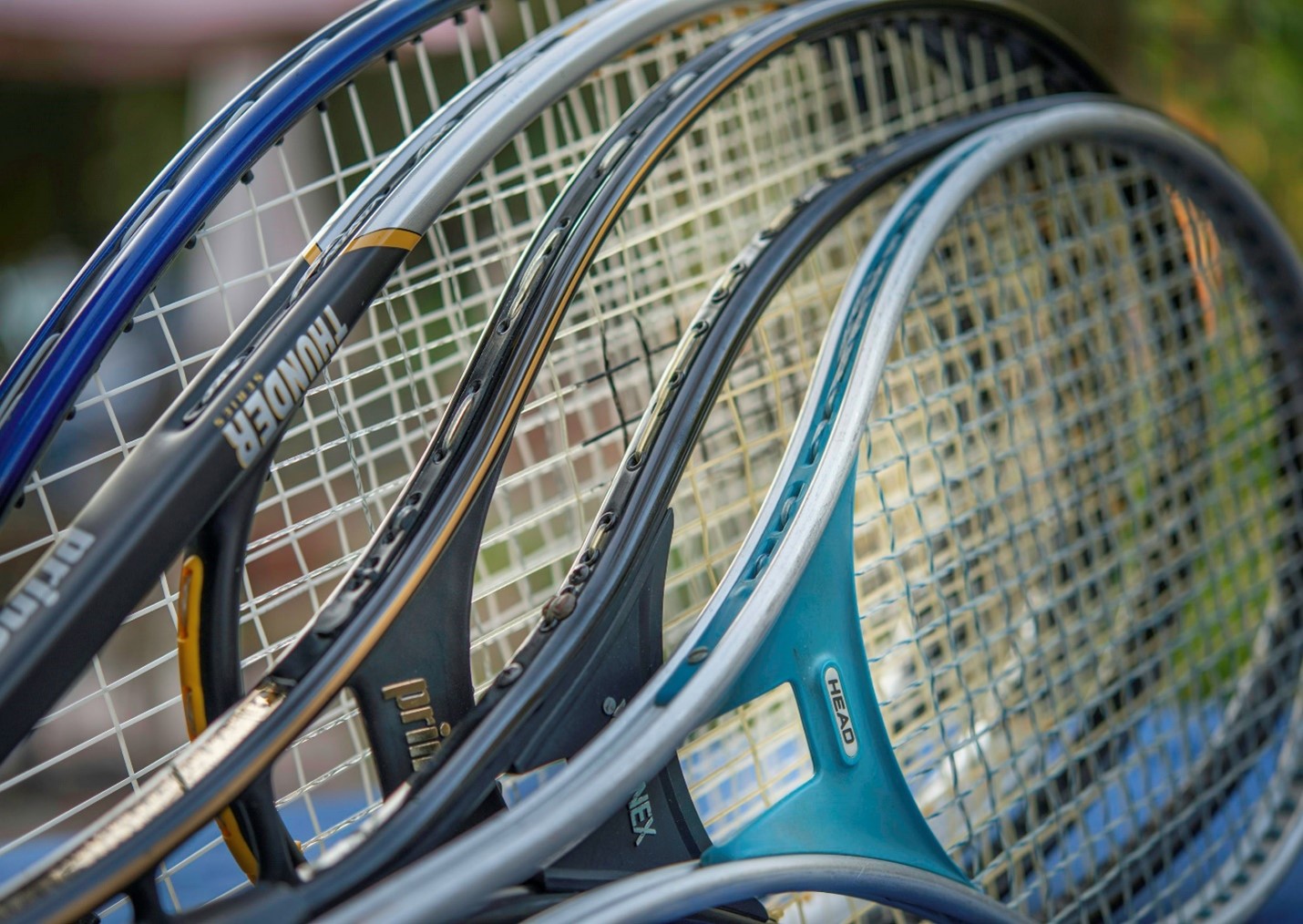 Tennis racquets of various sizes lined up.