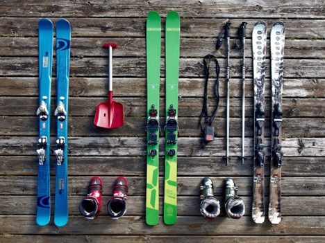 Skis and gear on a wooden surface.